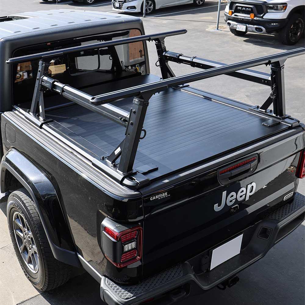 Black Jeep gladiator retractable cover with a ladder rack in a parking lot