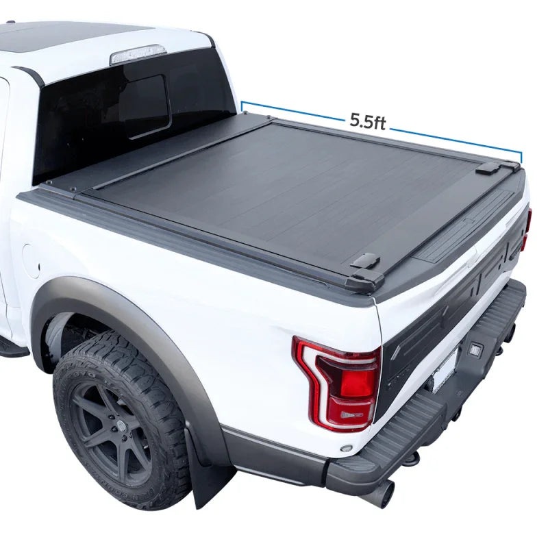 Retractable tonneau cover made of aluminum installed on the bed of a white f150 truck.