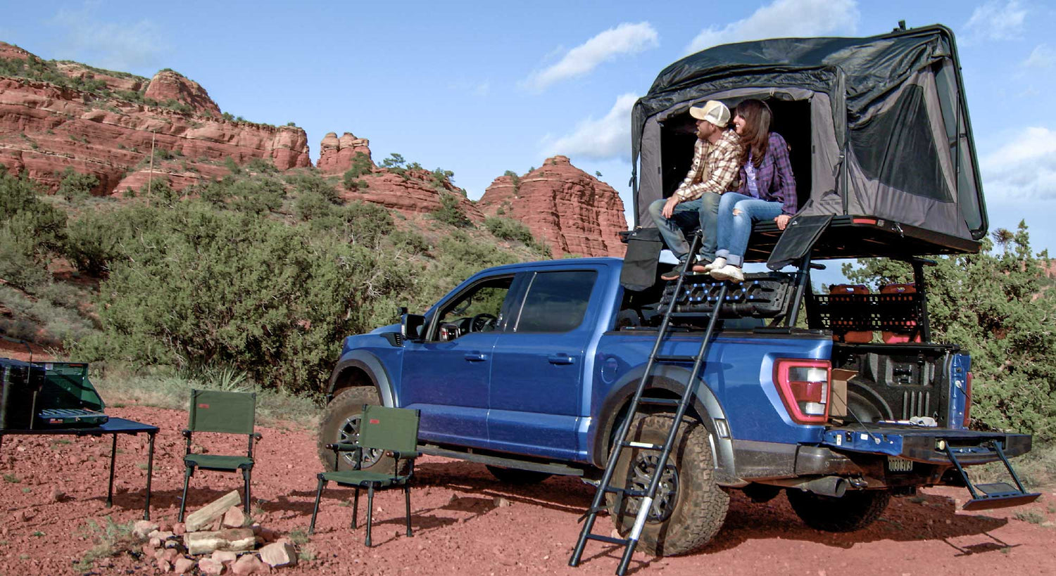 Blue truck with a rooftop tent in a desert setting