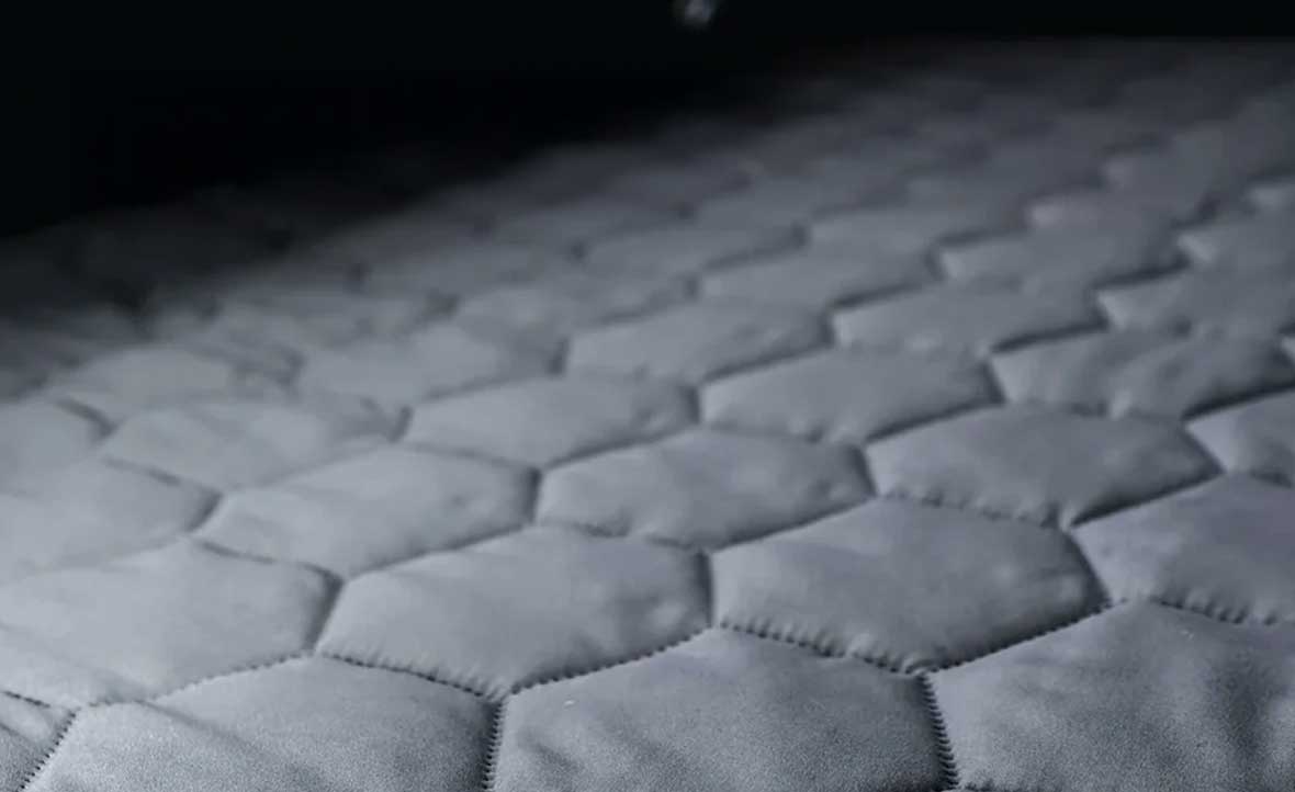Hexagonal patterned mattress surface with a dark background