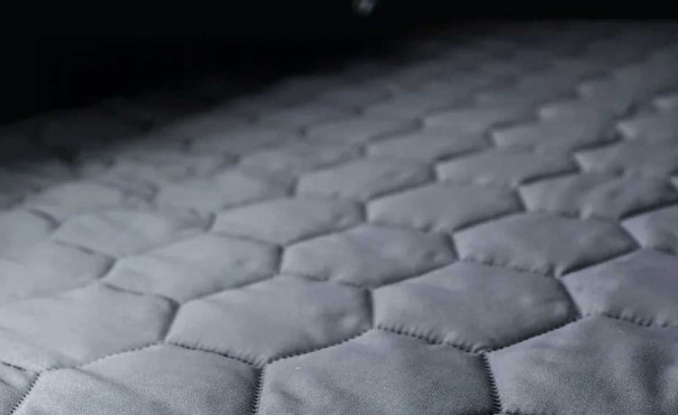 Hexagonal patterned mattress surface with a dark background