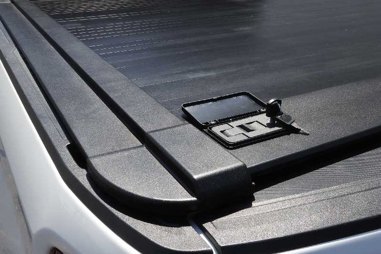 Close-up of a truck bed cover with a logo on a vehicle