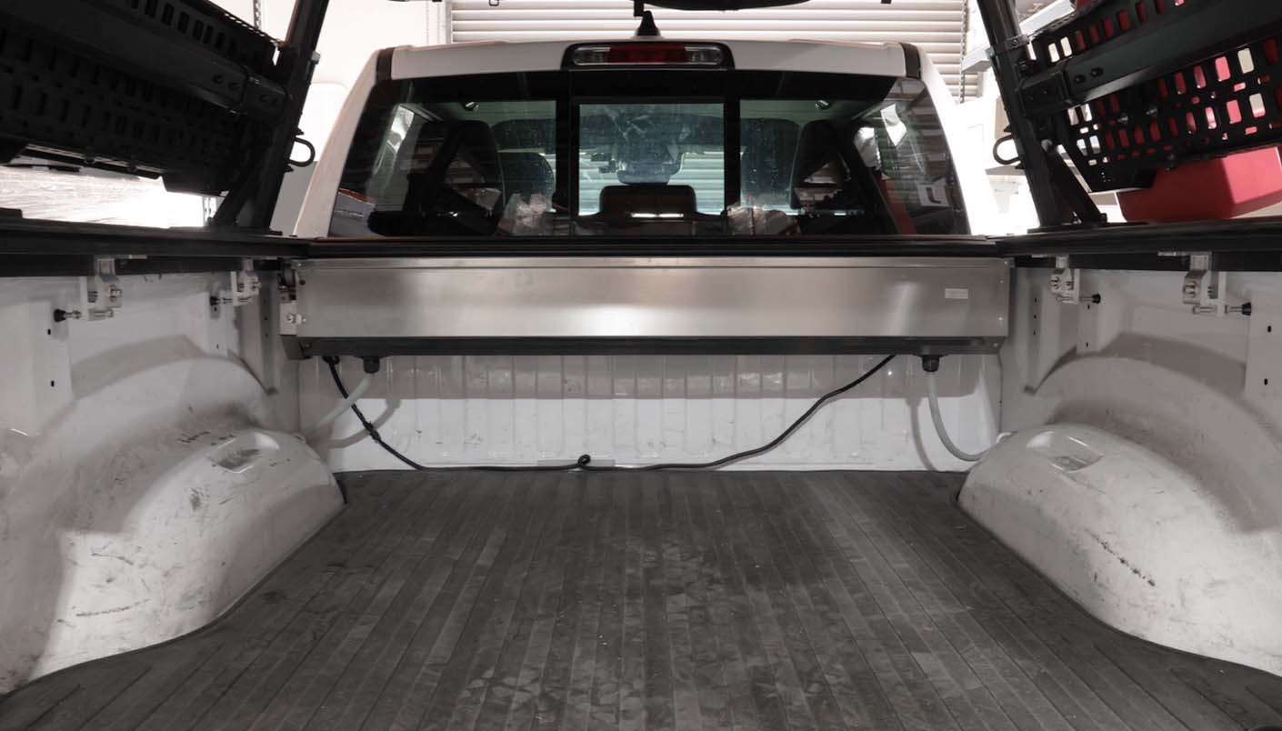 full view of truck bed with silver canister, clamps, and drainage system