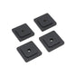 Four black square rubber washers with central holes on a white background