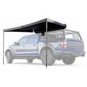 Black truck bed side awning cover on a blue pickup truck with a white background