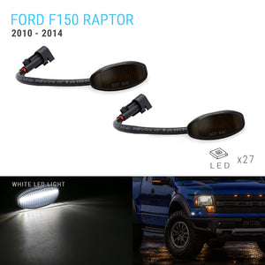 Two Ford F150 Raptor 2010-2014 DOT 6 LED side marker lights shown on a white background, with one light illuminated in a dark scene and a blue truck pictured in the lower right corner. Text reads 'FORD F150 RAPTOR 2010 - 2014', 'WHITE LED LIGHT', and 'LED x27'.