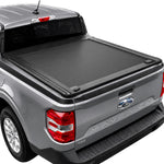 A black roll-up truck bed cover installed on the bed of a gray Ford Maverick pickup truck, shown from a rear three-quarter angle against a white background.