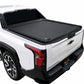 A double t-slot retractable bed cover installed on the bed of a white pickup truck, shown from a rear three-quarter angle against a plain white background.