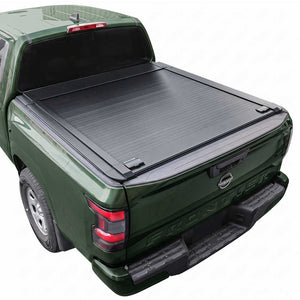 A black Frontier 6ft truck bed cover installed on the bed of a dark green pickup truck, shown from a rear three-quarter angle against a plain white background.