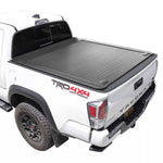 White Toyota Tacoma truck with a black enhanced mb tonneau cover on a white background