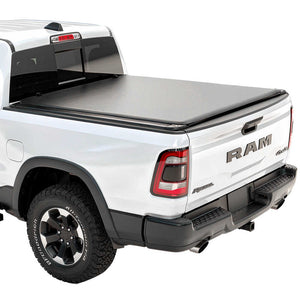 White Ram truck with a soft roll-up tonneau cover on a white background
