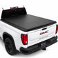 A syneticusa roll-up truck bed cover installed on the bed of a white GMC Sierra pickup truck, shown from a rear three-quarter angle on a white studio background.