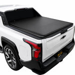 A black tonneau cover installed over the bed of a white Silverado EV truck, shown from a rear three-quarter angle against a plain white background.