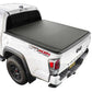 White Tacoma truck with a black soft roll up tonneau cover on a white background