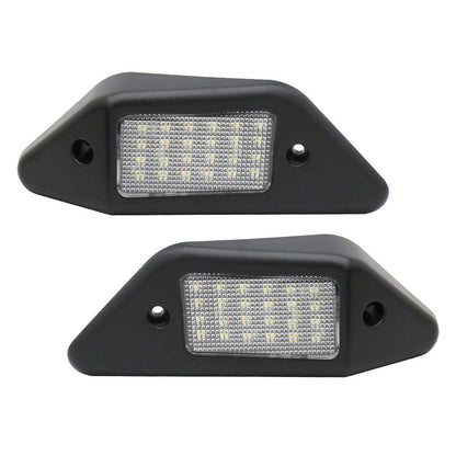 Two black LED license plate lights on a white background