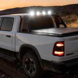 White pickup truck with roof lights on a desert landscape at sunset