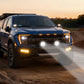 Blue pickup truck on a dirt road with sunset in the background
