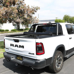 White Ram truck with a black soft roll up tonneau cover on a street.