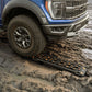 close up use of traction recovery board in a dirt road