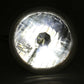 Round headlight with reflective surface on a black background
