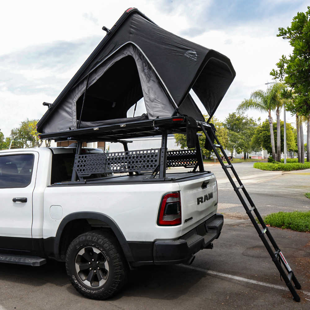 White Ram rebel with PRO Quad Pack and a bush cruiser rooftop tent and ladder on a street.