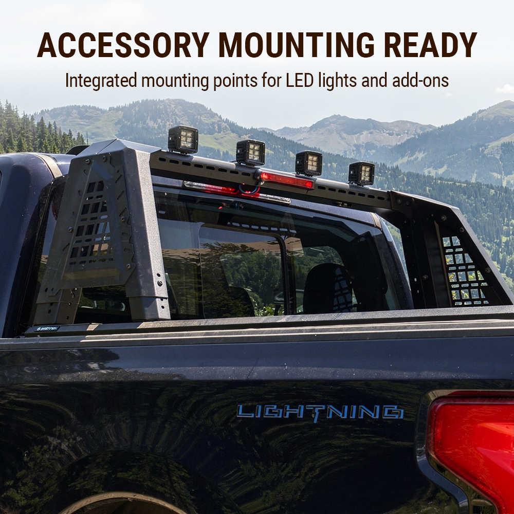 Back of a truck with accessory mounting points for LED lights and add-ons, set against a mountainous landscape.