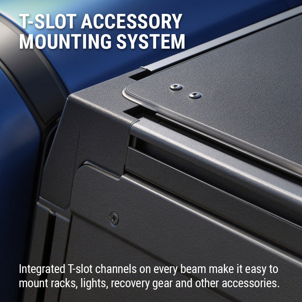 Close-up of a dark gray T-slot mounting system on a vehicle frame, with white text reading 'T-SLOT ACCESSORY MOUNTING SYSTEM' at the top and descriptive text at the bottom.