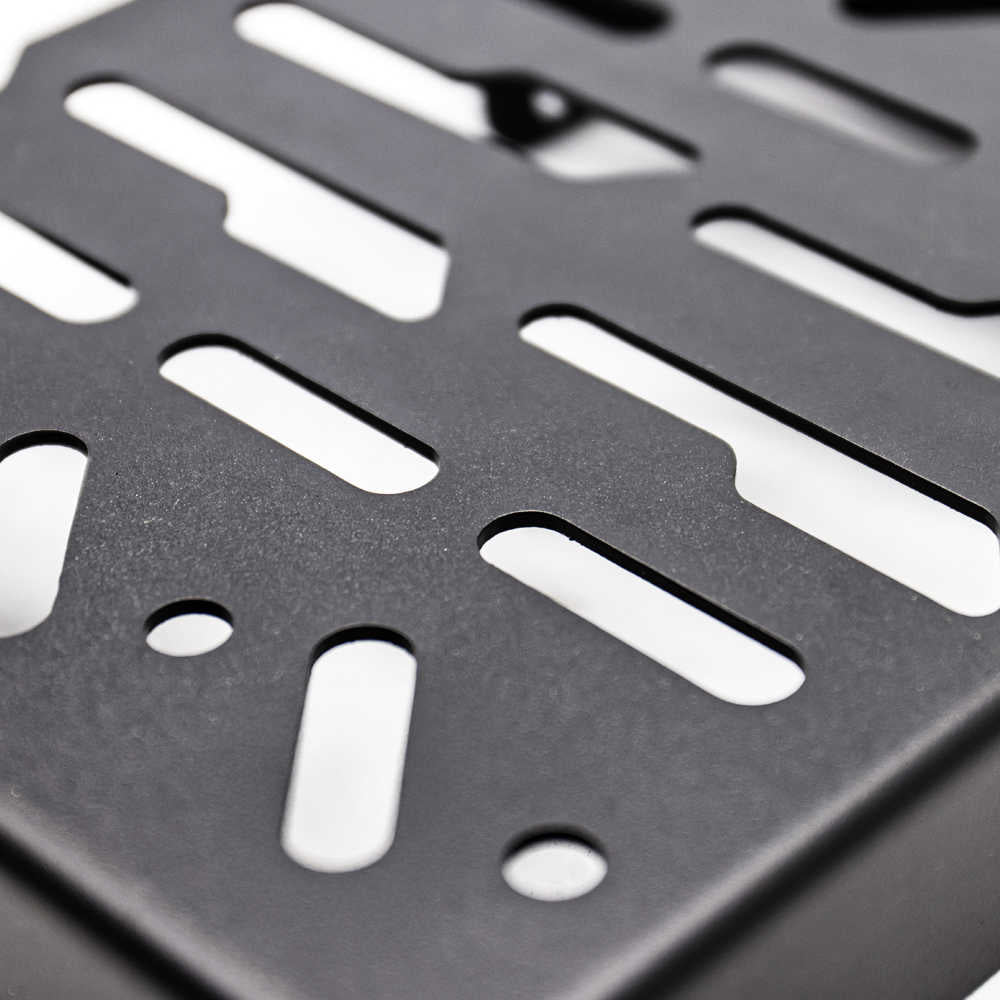 Close-up of a black metal mounting plate with elongated and circular cutouts, showing a matte textured surface.