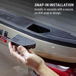 A hand holding a black snap-in step pad next to a beige truck bed, with text reading 'SNAP-IN INSTALLATION' and 'Installs in seconds with a secure, no-drill snap-in design.'.