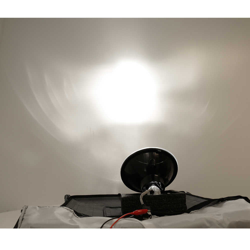 Black headlamp on a white surface with a light gray background