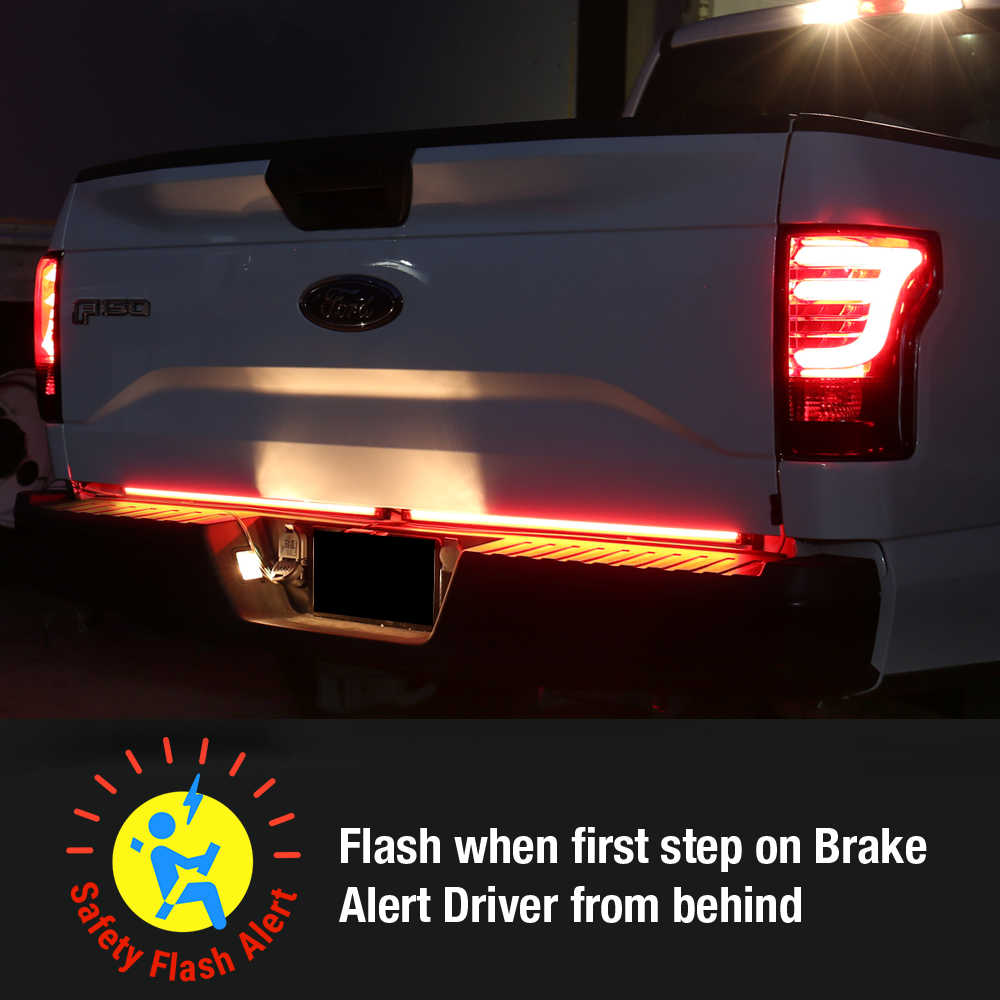 Back of a white truck with a safety flasher light system on a dark background