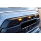 Close-up of a Tacoma's front grille with illuminated indicator lights.