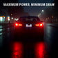 A dark sedan photographed from the rear on a wet nighttime city street, with bright red taillights glowing and reflecting on the road. Large white text at the top reads “MAXIMUM POWER, MINIMUM DRAW.