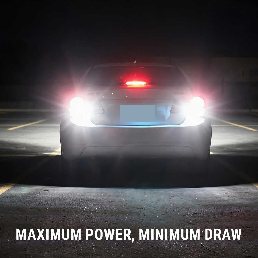 A car photographed from the rear at night with bright headlights turned on, casting strong light beams on a dark parking-lot surface. White text at the bottom reads “MAXIMUM POWER, MINIMUM DRAW.