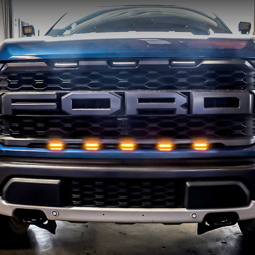 Close-up of a Ford vehicle 5 pods grille light with illuminated orange front grille lights.