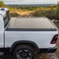 White truck with a tonneau cover on a dirt road with a scenic background