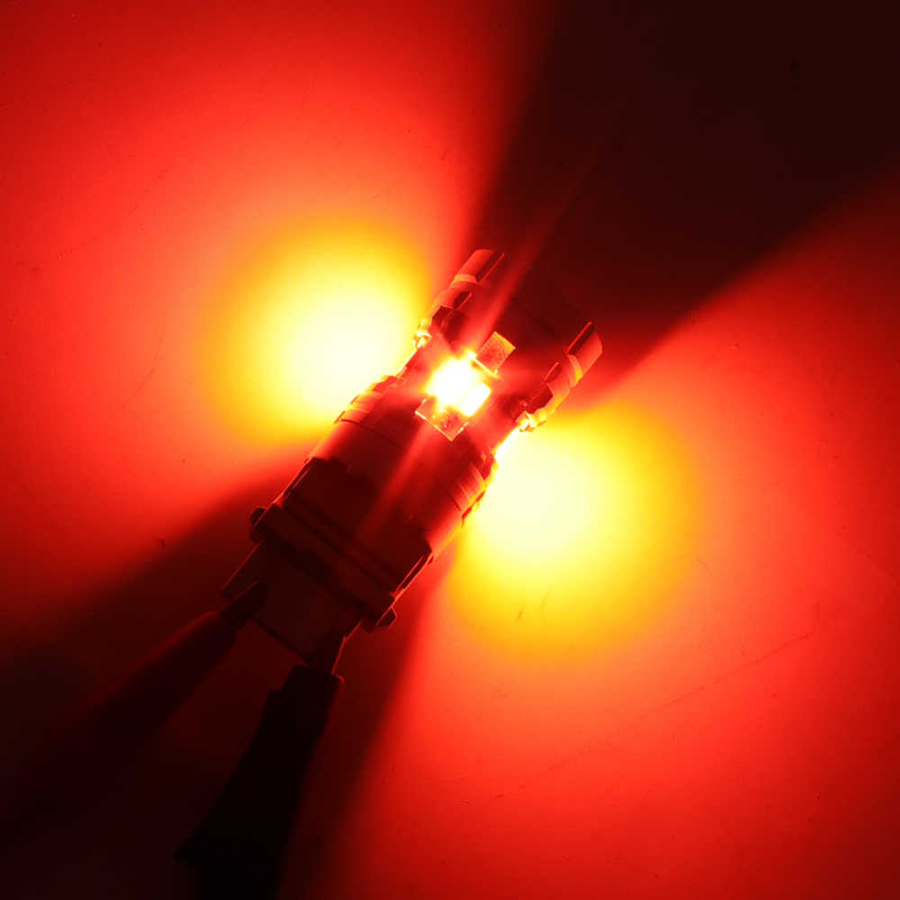 A close-up of a small automotive light bulb or connector emitting a bright red and yellow glow against a dark red background.