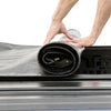 Person unrolling a black and gray rolling tonneau cover.