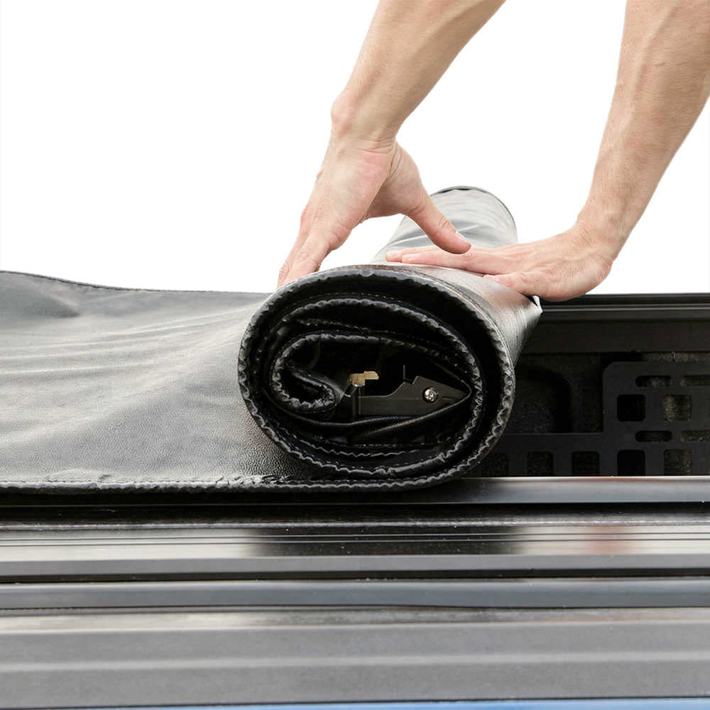 Person unrolling a black and gray rolling tonneau cover.