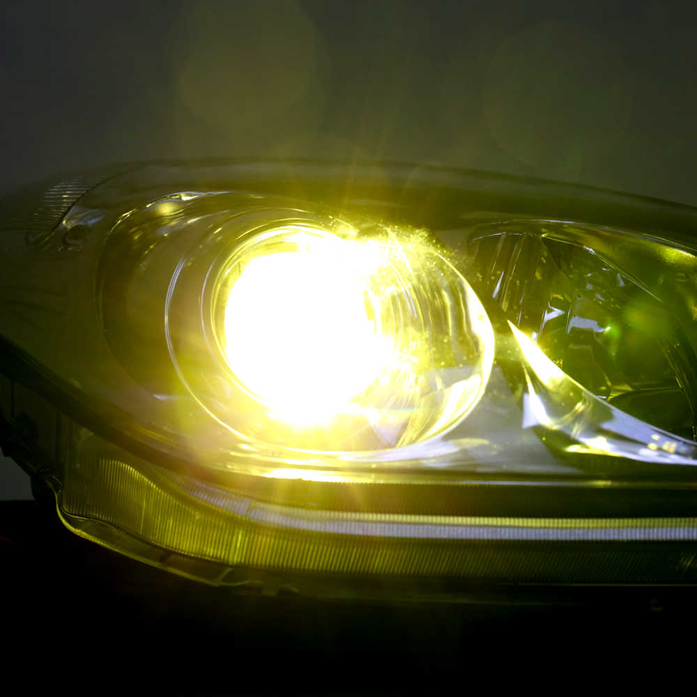 Car headlight with a bright yellow glow in a dark setting