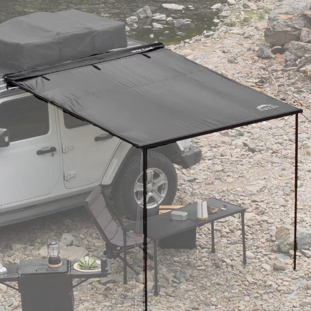Car roof side awning set up on a vehicle by a rocky area