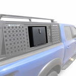 A blue pickup truck with a gray SYNETICUSA modular cap and storage compartment system, shown on a clean white background.