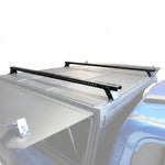 Black metal roof rack crossbars mounted on a syneticusa flex modular cap, shown against a white studio background.
