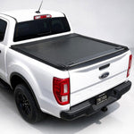 A black roll-up truck bed cover installed on the bed of a white Ford Ranger pickup truck, shown from a rear three-quarter angle on a light gray studio background.