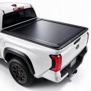 A black roll-up truck bed cover installed on the bed of a white pickup truck, shown from a rear three-quarter angle against a clean white studio background.