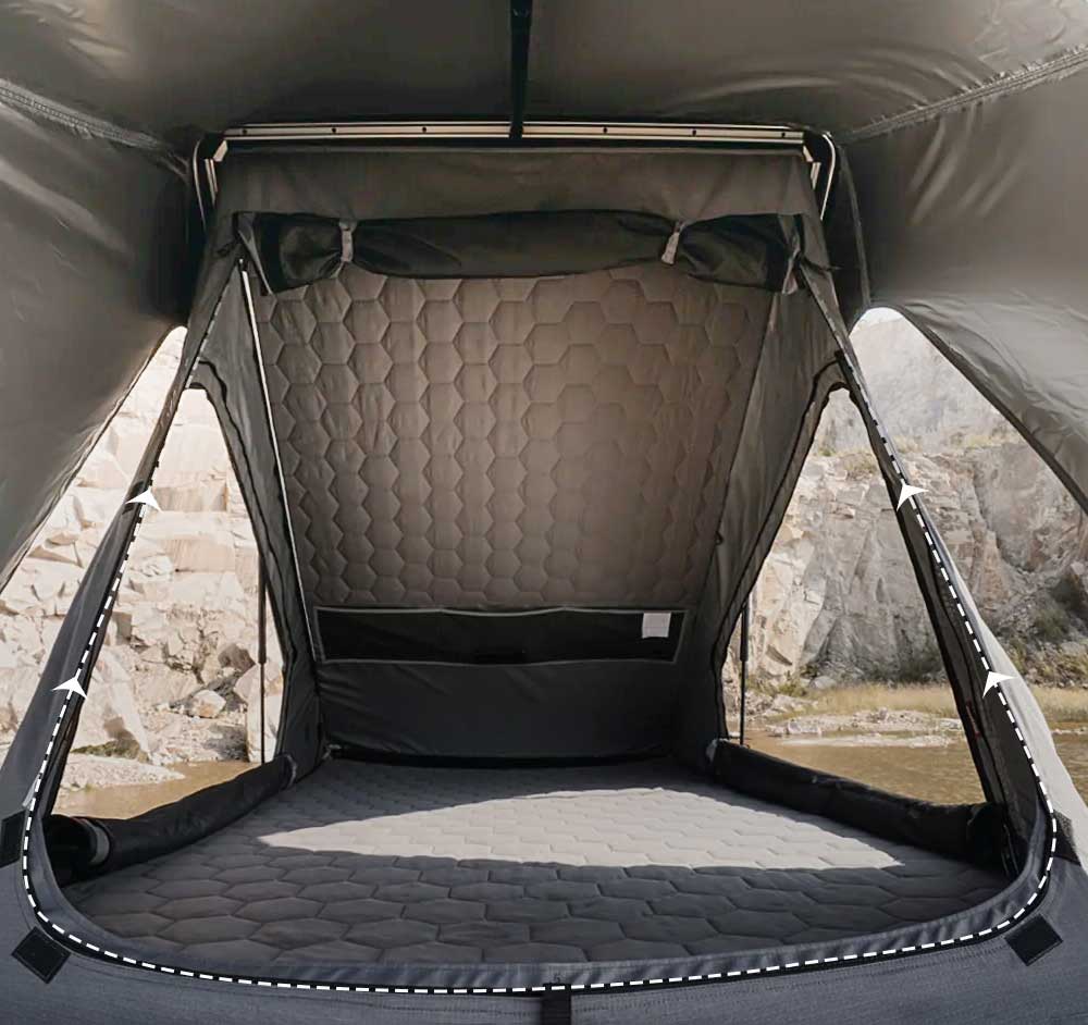 Camping pod with quilted interior and quilted floor, set against a natural landscape.