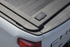 Close-up of a truck bed with enhanced MB retractable tonneau cover and Chevrolet logo.
