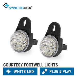 Two Synetic USA courtesy footwell lights with white LED lenses and black mounting brackets, shown on a white background with product feature labels at the bottom.