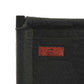 Close-up of a green canvas  and a brown leather patch with the Wild Land.logo.