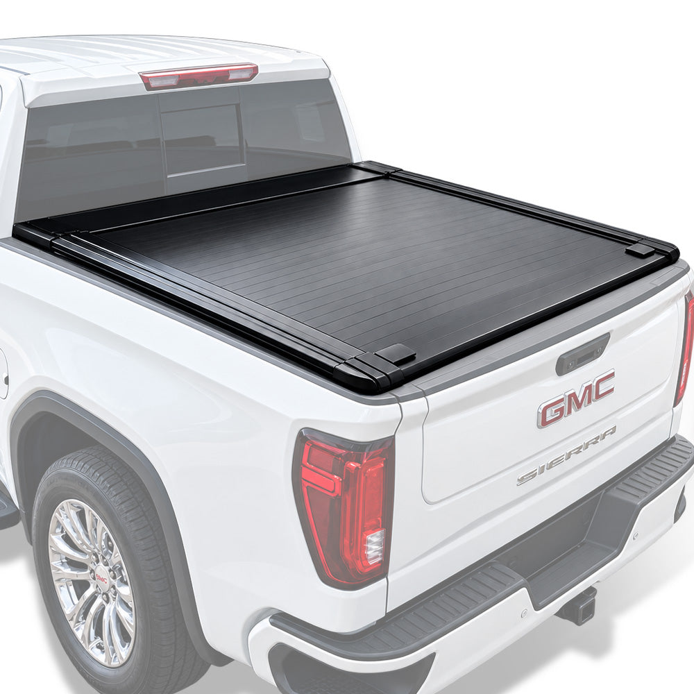 A black truck bed cover installed on the bed of a white GMC Sierra pickup truck, shown from a rear three-quarter angle against a clean white background.